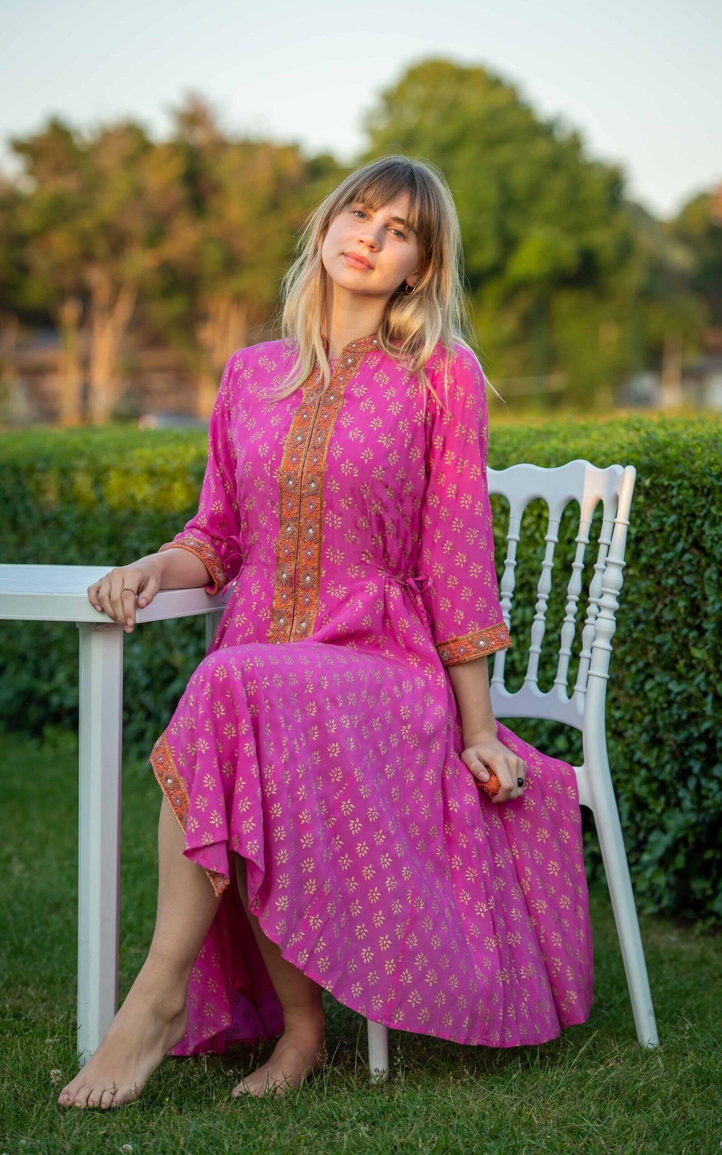 Detail view of fuchsia silk angharkha dress with flowing fabric by Kaminee