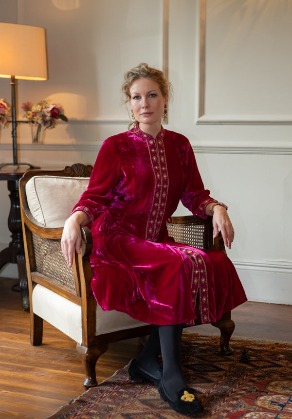 Detail view of fuchsia embroidered velvet dress fabric and silhouette by Kaminee