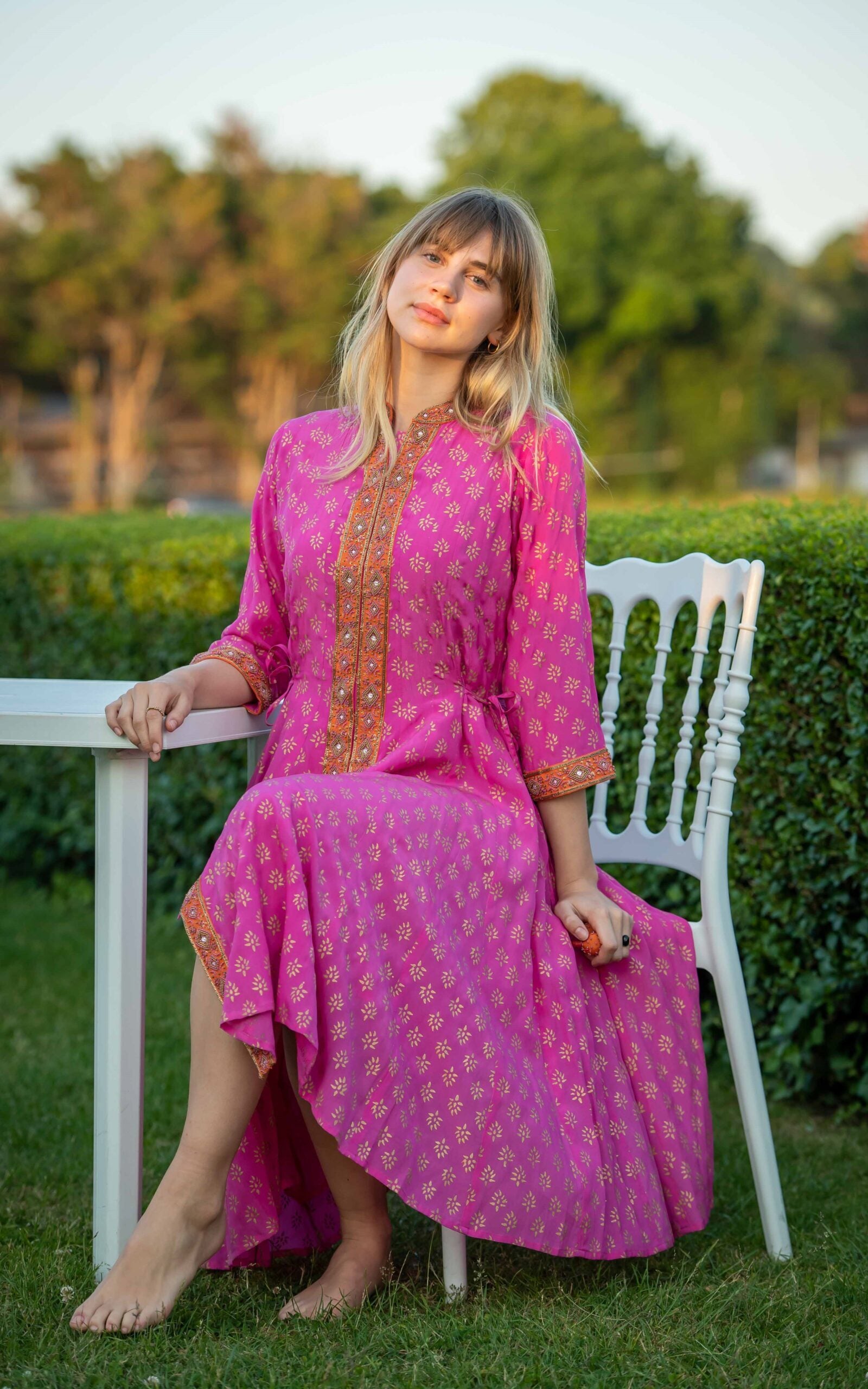 Detail view of fuchsia silk angharkha dress with flowing fabric by Kaminee